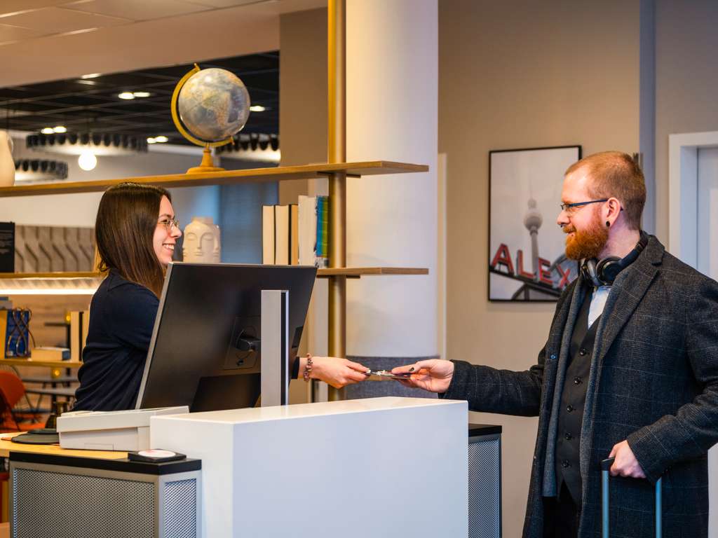 Gast beim Check-in an der Rezeption des ibis Berlin Mitte