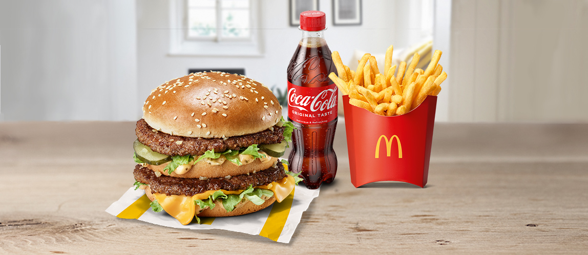 Offizielle McDelivery-Szene mit Burger, Pommes und Getränk zu Hause